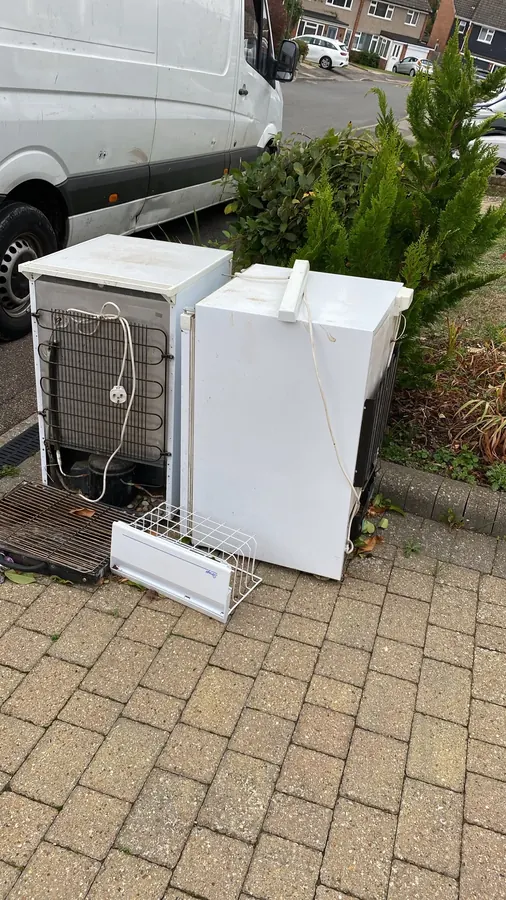 Before: an old fridge and dishwasher on a driveway