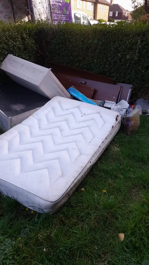 Mattress and bed base ready for collection in a front garden
