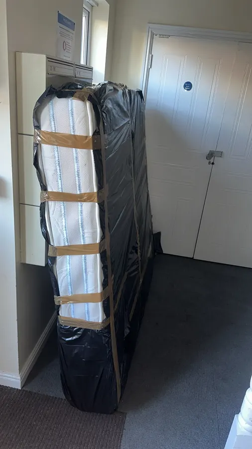 Wrapped mattress collected from a flat hallway